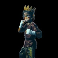 a young girl in a boxing costume with a crown on her head