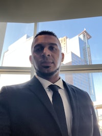 a man in a suit standing in front of a window